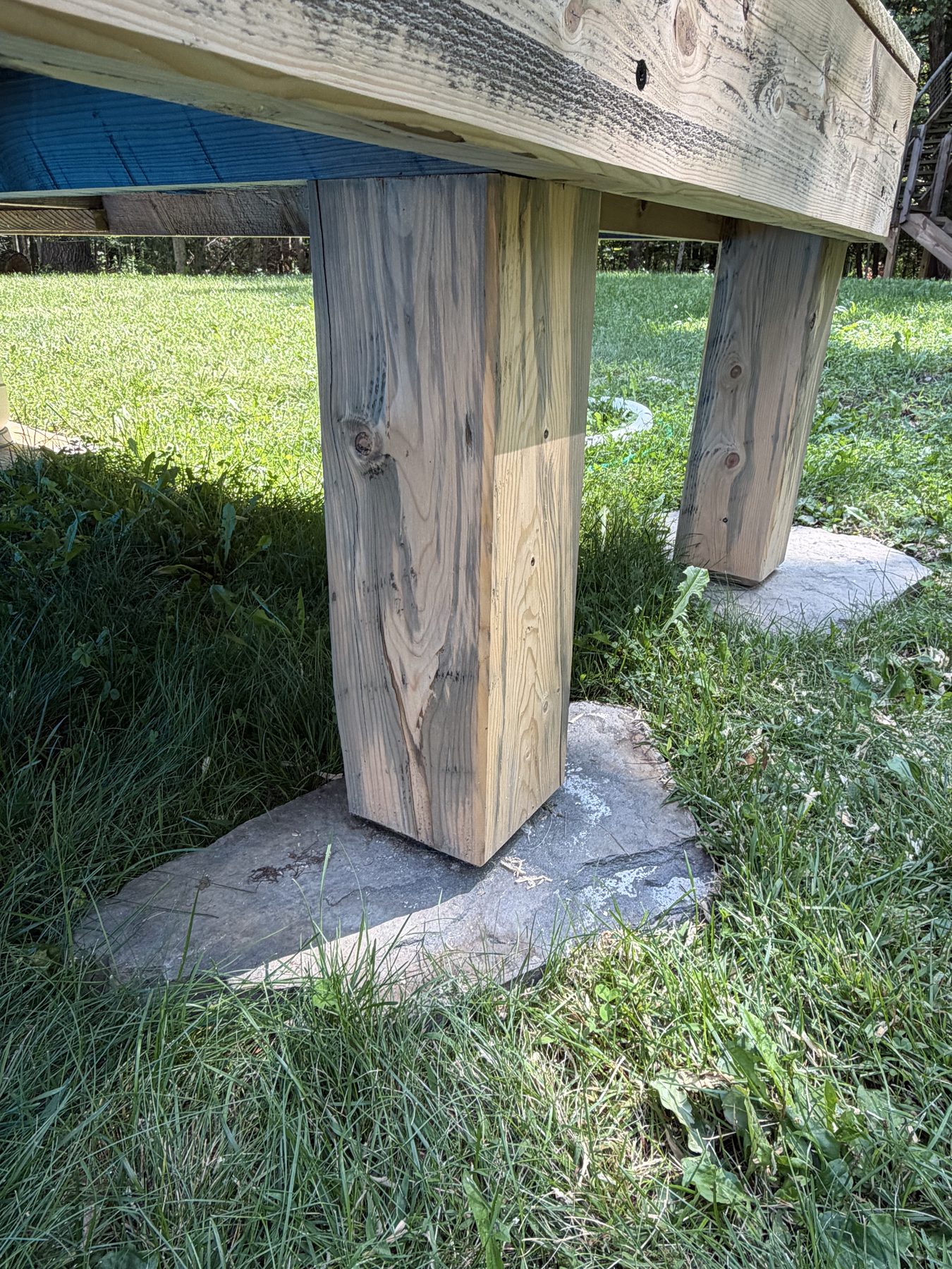 Deck support post resting on a stone footer